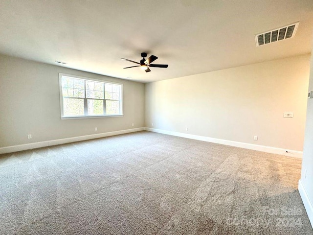 empty room featuring ceiling fan and carpet