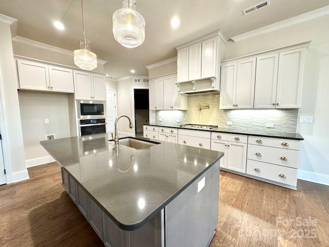 kitchen with tasteful backsplash, visible vents, appliances with stainless steel finishes, crown molding, and a sink