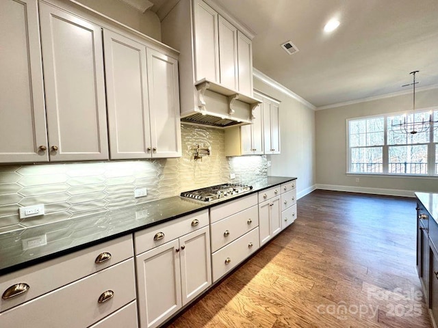 kitchen with visible vents, ornamental molding, decorative backsplash, dark wood finished floors, and stainless steel gas stovetop