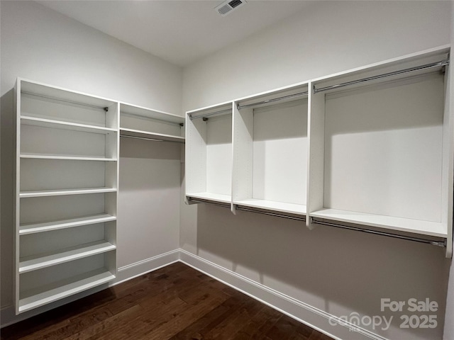 spacious closet featuring dark wood-type flooring and visible vents