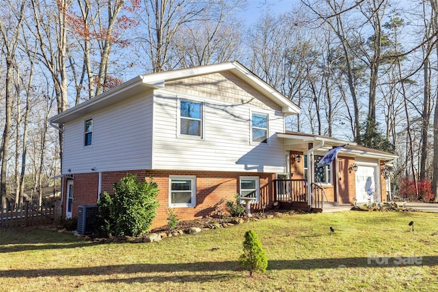 tri-level home featuring central air condition unit and a front yard