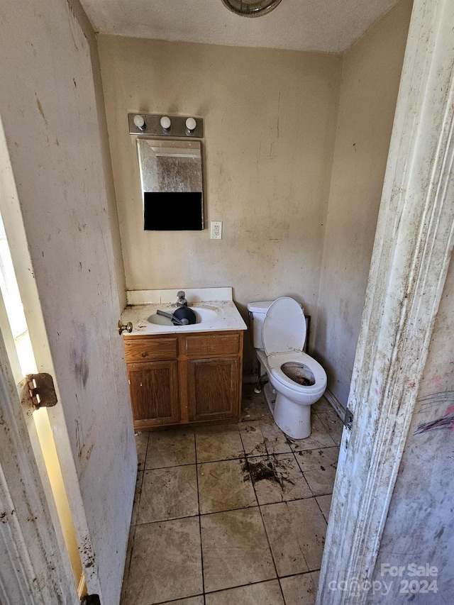 bathroom with tile patterned floors, vanity, and toilet