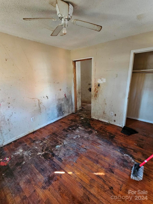 unfurnished bedroom featuring ceiling fan, hardwood / wood-style floors, and a textured ceiling