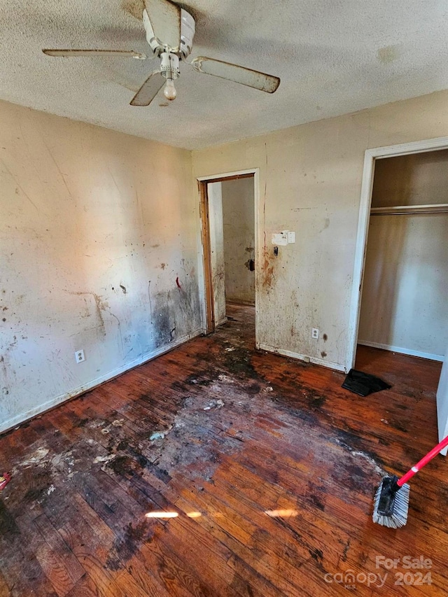 unfurnished bedroom featuring hardwood / wood-style floors, ceiling fan, and a textured ceiling