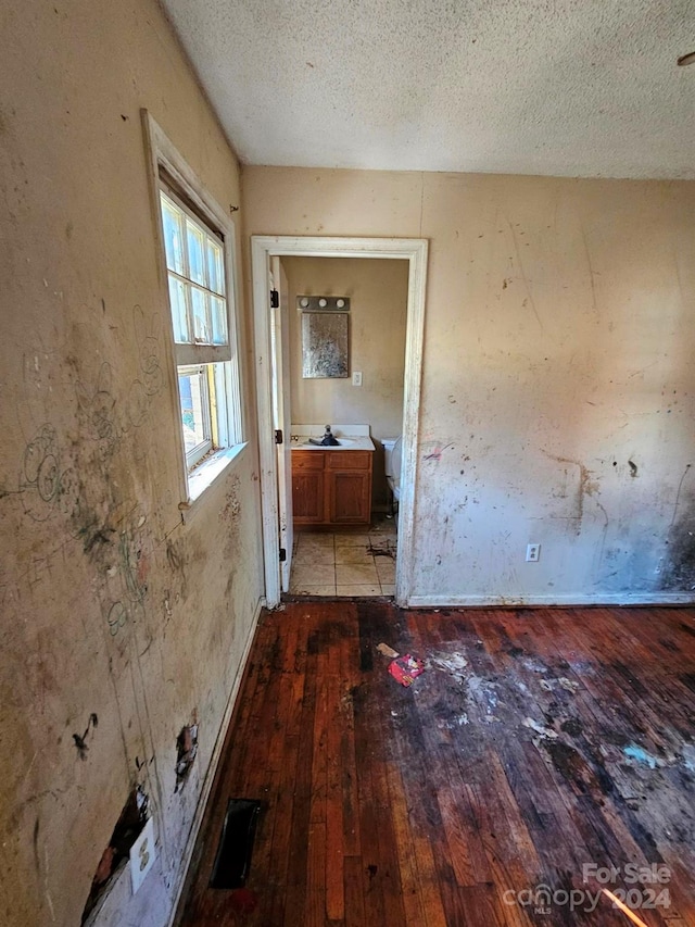 hall featuring a textured ceiling and light wood-type flooring