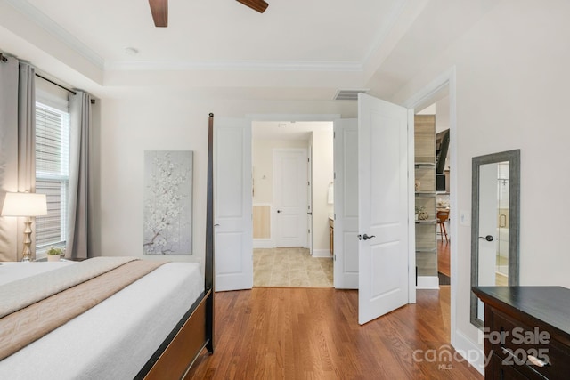 bedroom featuring hardwood / wood-style floors, ceiling fan, and crown molding