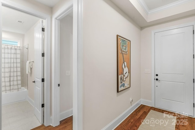 entryway featuring wood-type flooring and ornamental molding