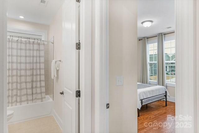 bathroom with shower / tub combo, toilet, and wood-type flooring