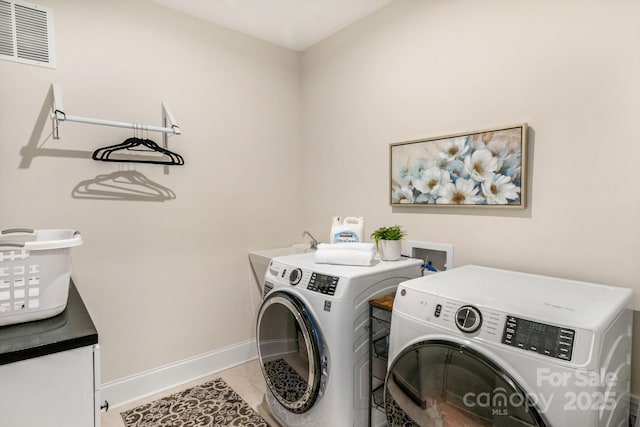 washroom with light tile patterned floors and washing machine and clothes dryer