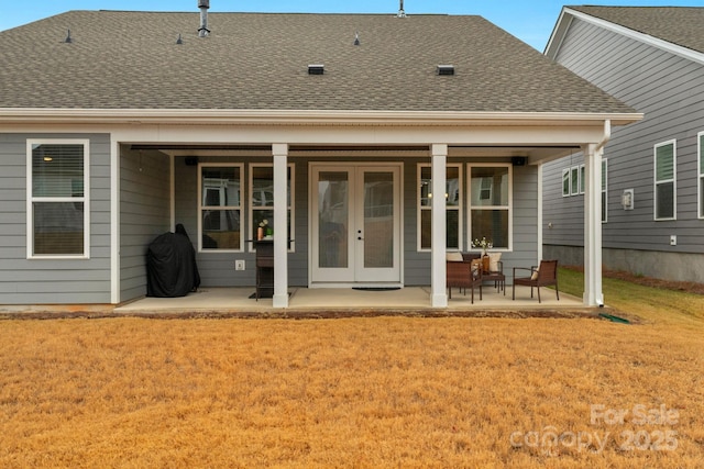 back of house featuring french doors and a lawn