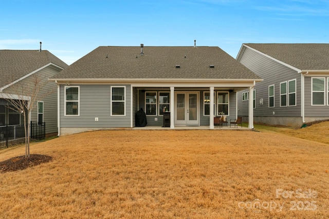 rear view of house featuring french doors, a patio area, and a lawn