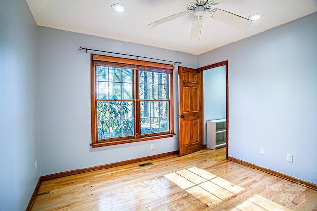 spare room with light wood-type flooring and ceiling fan