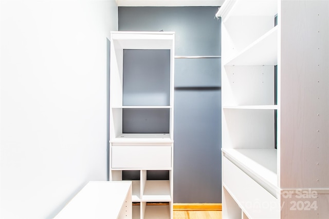 walk in closet with hardwood / wood-style flooring