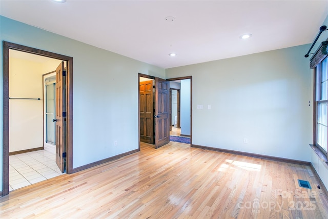 unfurnished room with light wood-type flooring and baseboards