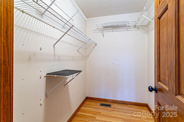 spacious closet featuring light wood-style flooring and visible vents