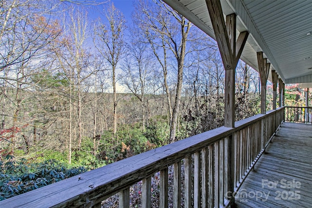 wooden terrace featuring a forest view