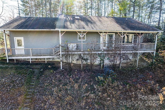 rear view of house featuring a shingled roof