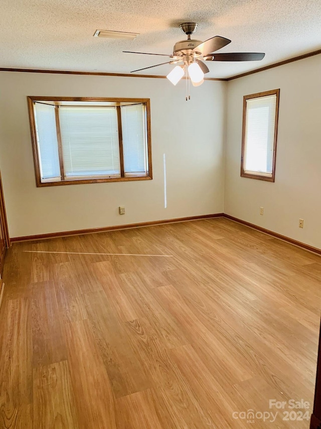 spare room with a textured ceiling, light hardwood / wood-style floors, and ceiling fan