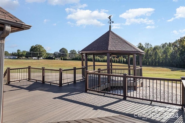 wooden terrace featuring a gazebo and a lawn