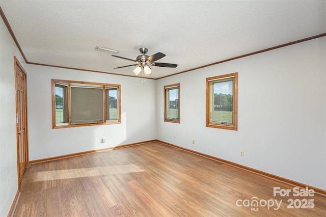 unfurnished room featuring light wood-type flooring, baseboards, and a textured ceiling