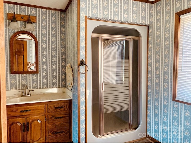 bathroom featuring a shower stall, vanity, and wallpapered walls