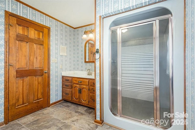 bathroom with wallpapered walls, baseboards, crown molding, vanity, and a shower stall