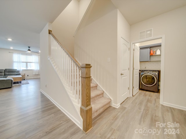 stairs featuring washer / clothes dryer, hardwood / wood-style flooring, and ceiling fan