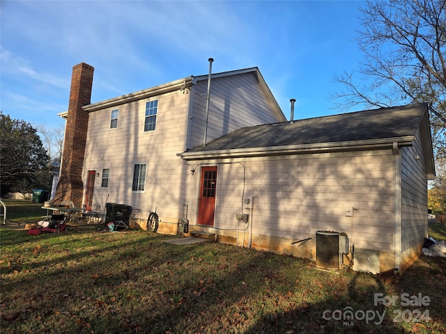 back of house featuring a yard and cooling unit