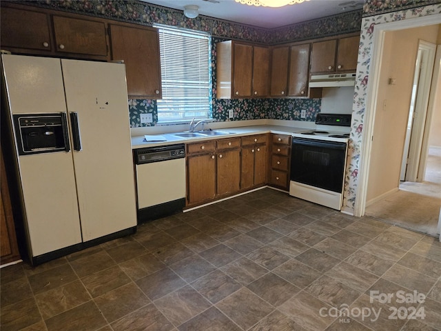 kitchen with white appliances, backsplash, and sink