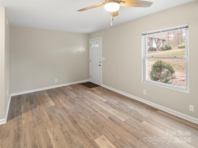 empty room with ceiling fan and light hardwood / wood-style flooring