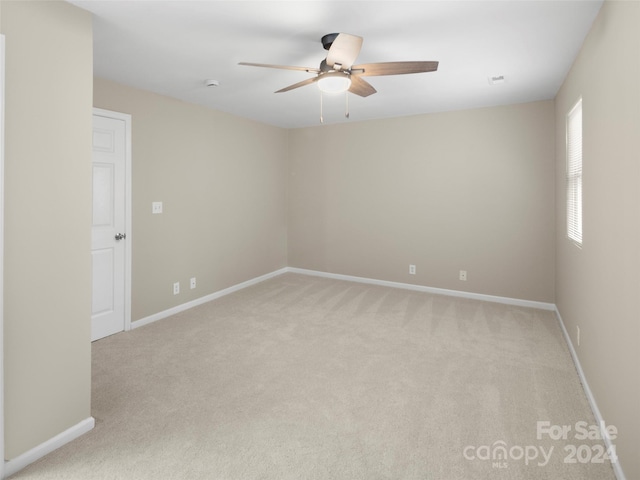 carpeted spare room with ceiling fan