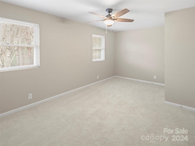 spare room featuring ceiling fan and light colored carpet