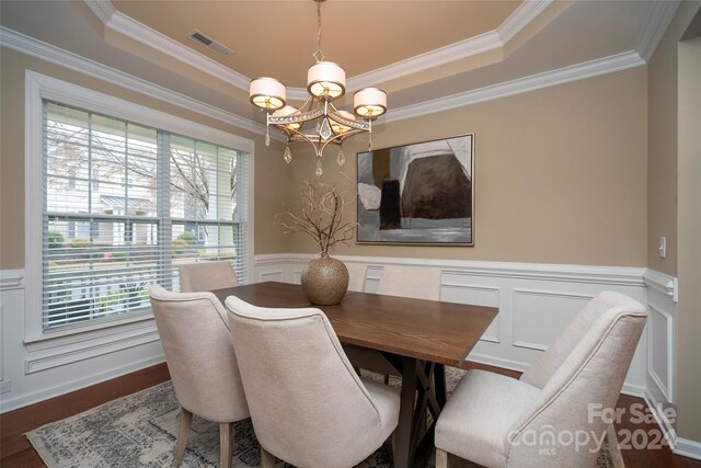 dining space featuring a wealth of natural light, dark hardwood / wood-style flooring, crown molding, and a notable chandelier