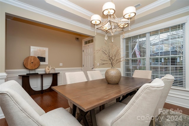 dining area featuring crown molding, hardwood / wood-style floors, and an inviting chandelier