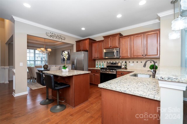 kitchen with dark hardwood / wood-style floors, kitchen peninsula, sink, and appliances with stainless steel finishes