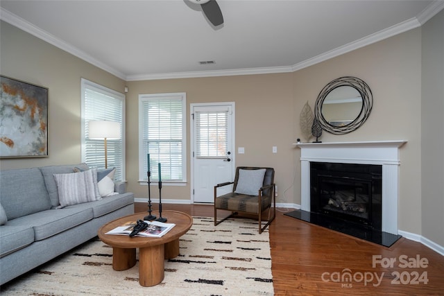 living room with hardwood / wood-style floors, ceiling fan, and ornamental molding