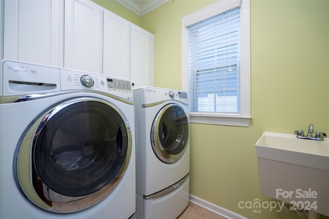 washroom featuring separate washer and dryer, crown molding, sink, and cabinets