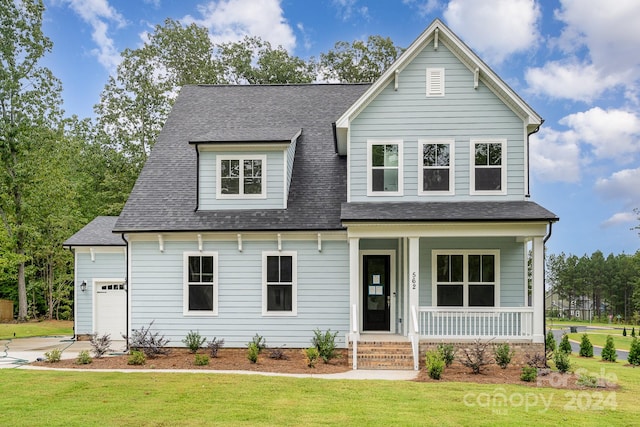 view of front facade featuring a front lawn, covered porch, and a garage