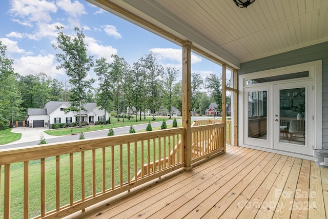 wooden terrace with a yard and french doors