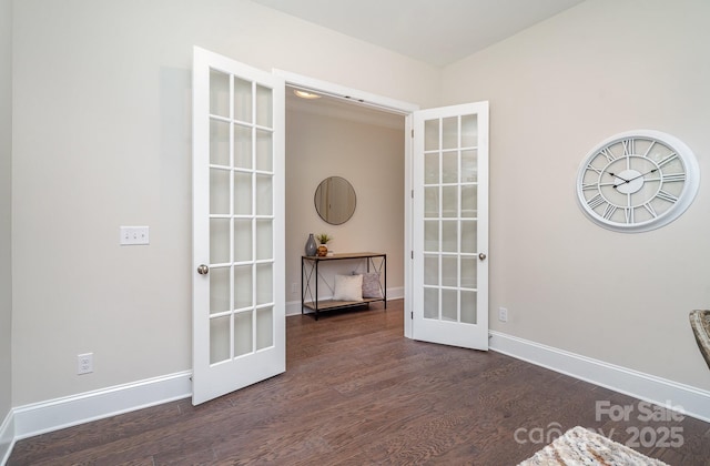 spare room with french doors, dark wood finished floors, and baseboards