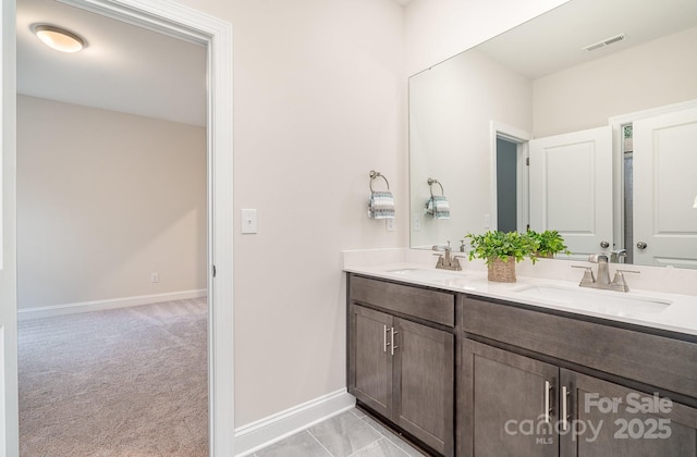 full bathroom with double vanity, visible vents, baseboards, and a sink