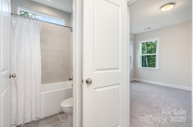 bathroom featuring shower / tub combo, baseboards, tile patterned flooring, and toilet