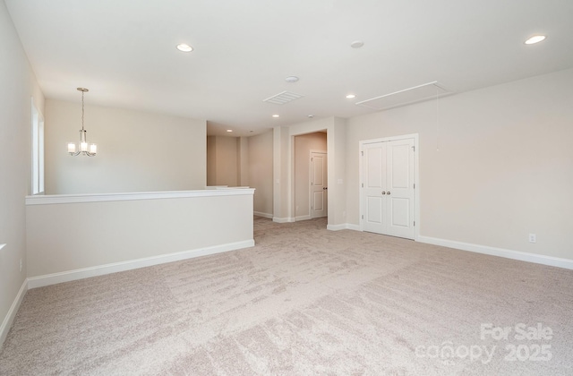 spare room featuring light carpet, attic access, baseboards, and recessed lighting