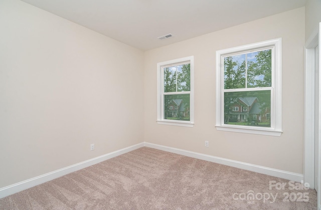 carpeted spare room with visible vents and baseboards