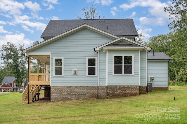 view of property exterior featuring roof with shingles, a lawn, and stairs