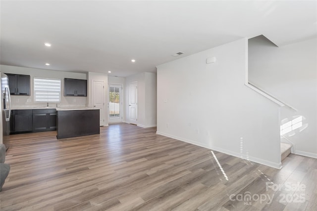 unfurnished living room with light wood-type flooring and sink