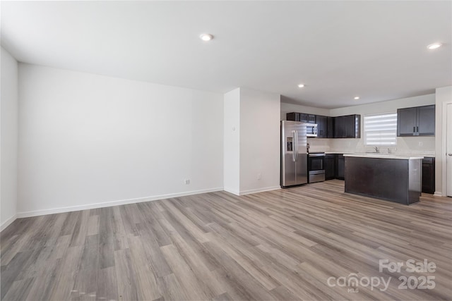 kitchen featuring a center island, sink, appliances with stainless steel finishes, and light hardwood / wood-style flooring