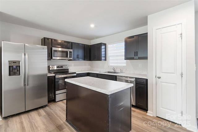 kitchen with a center island, light hardwood / wood-style flooring, stainless steel appliances, and sink