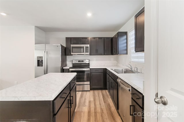 kitchen with sink, a center island, light hardwood / wood-style floors, and appliances with stainless steel finishes