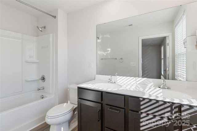 full bathroom with bathtub / shower combination, vanity, hardwood / wood-style flooring, and toilet